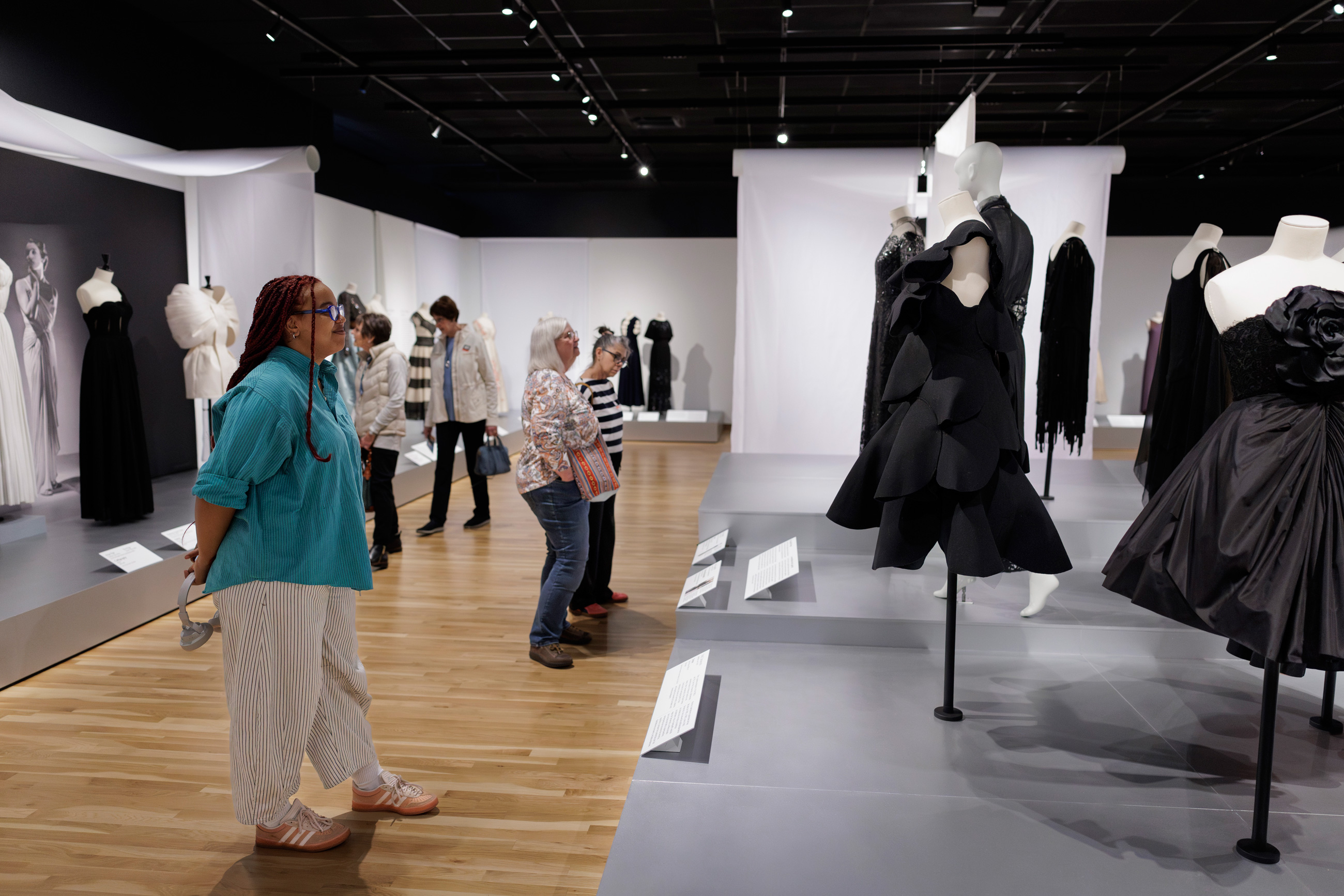 visitors looking at garments on display on platforms