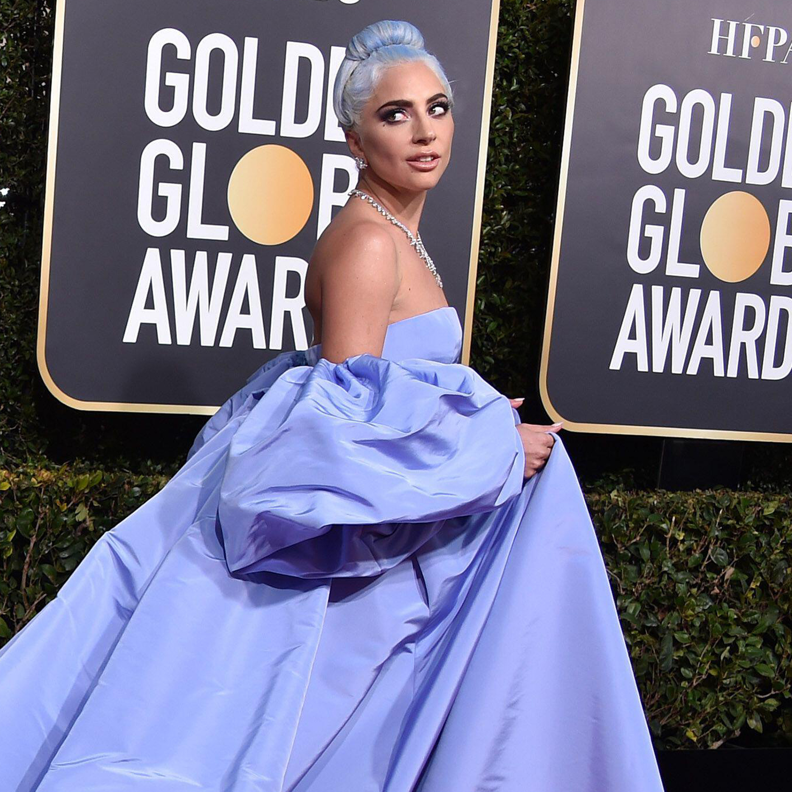 Lady Gaga on a red carpet in a blue gown