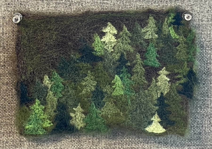 Wet felting textile made to resemble trees in a forest