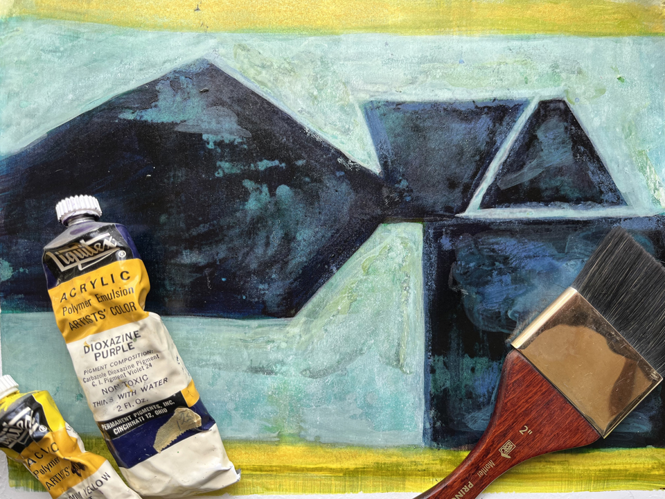 Abstract painting with paint and brush resting on the canvas in the foreground