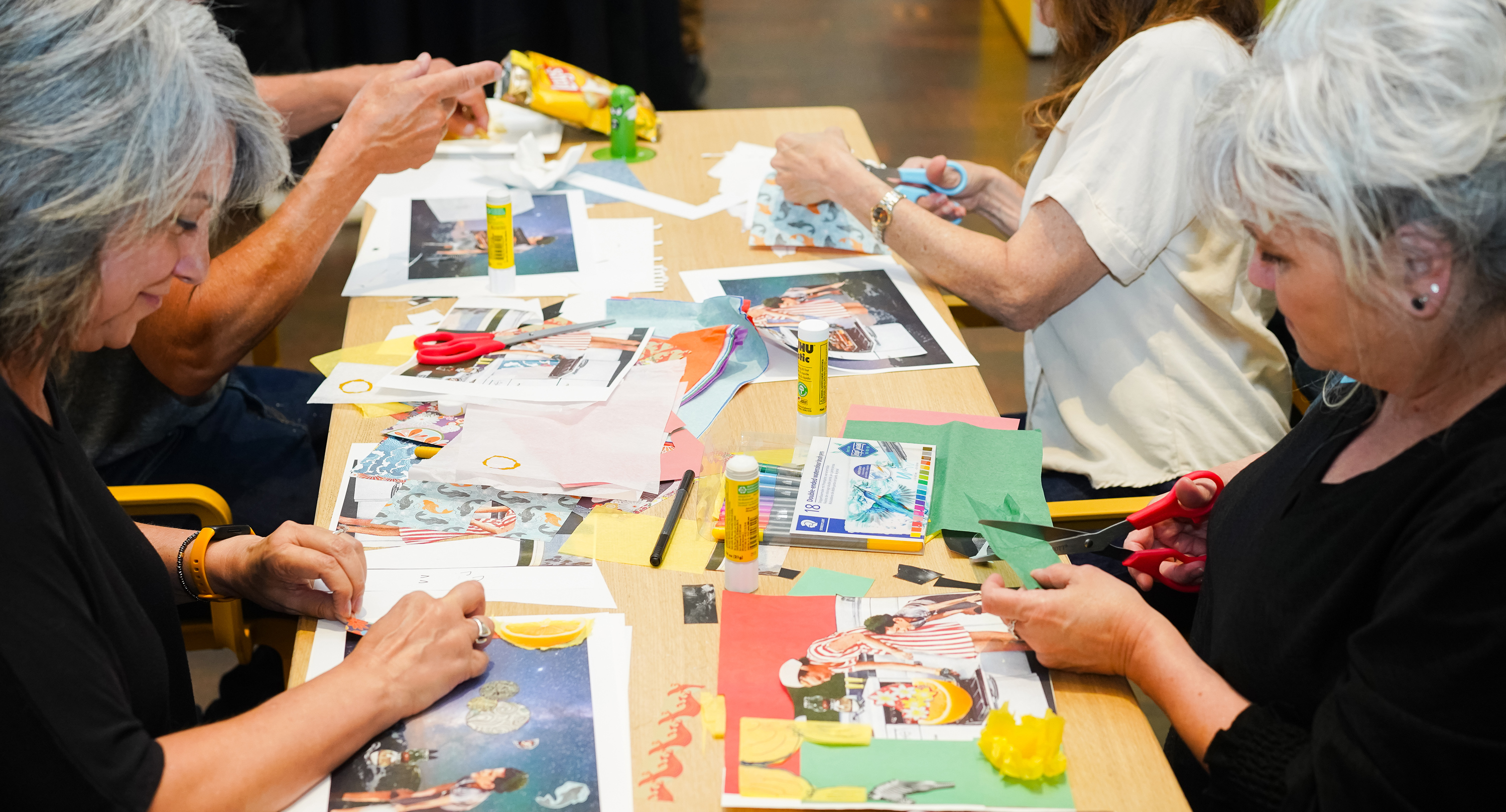 Two women doing arts and crafts on opposite sides of the table