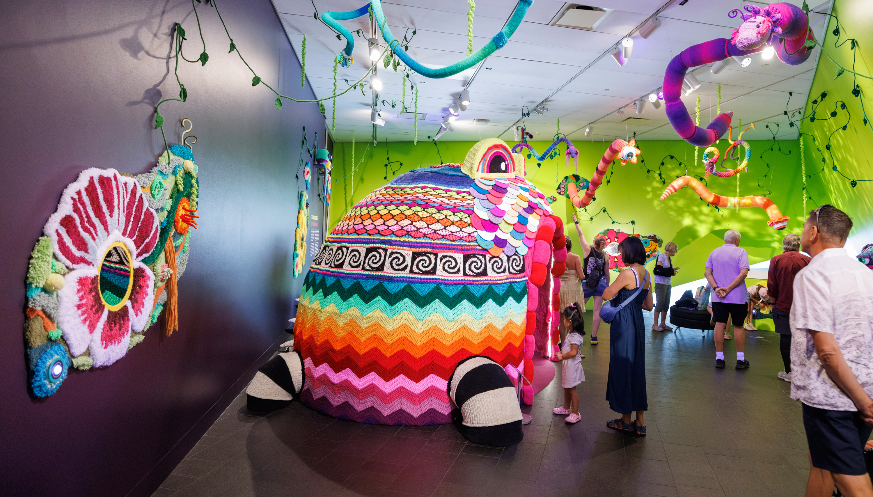 Visitors walking inside the colorful Tangled Self installation