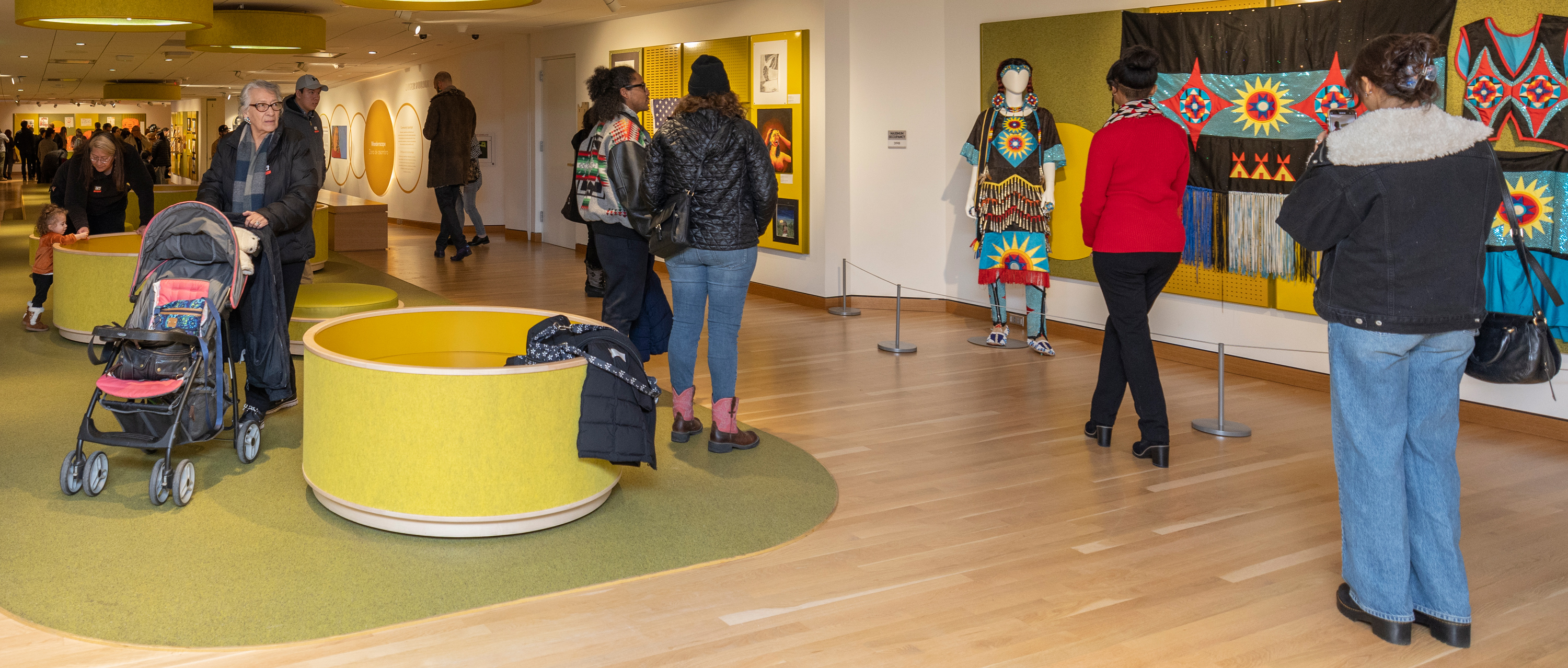 Wide gallery shot of visitors walking through Indomitably Indigenous in the Wonderscape