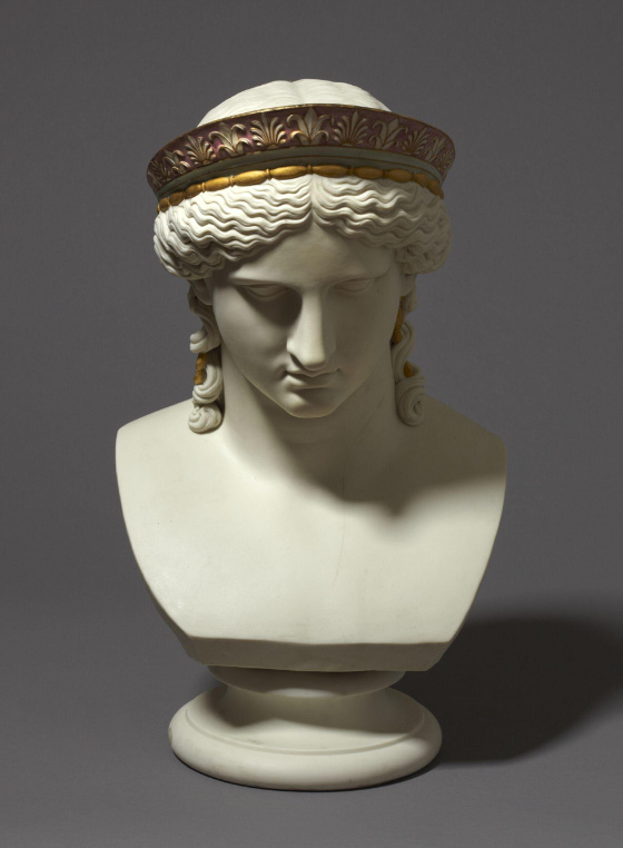 A white porcelain bust of a woman wear-ing a golden crown.