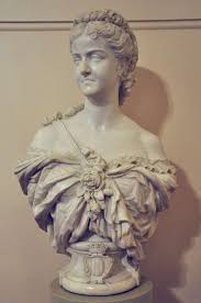 A white marble bust of a woman wearing voluminous layers of fabric around her shoulders, with floral and lace details.