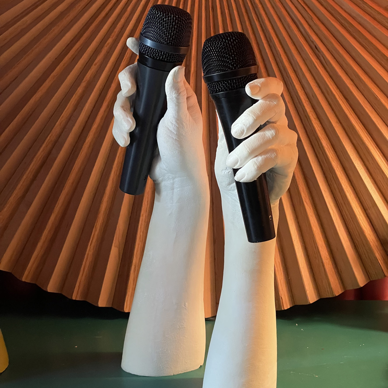 Two mannequin hands holding microphones in each hand