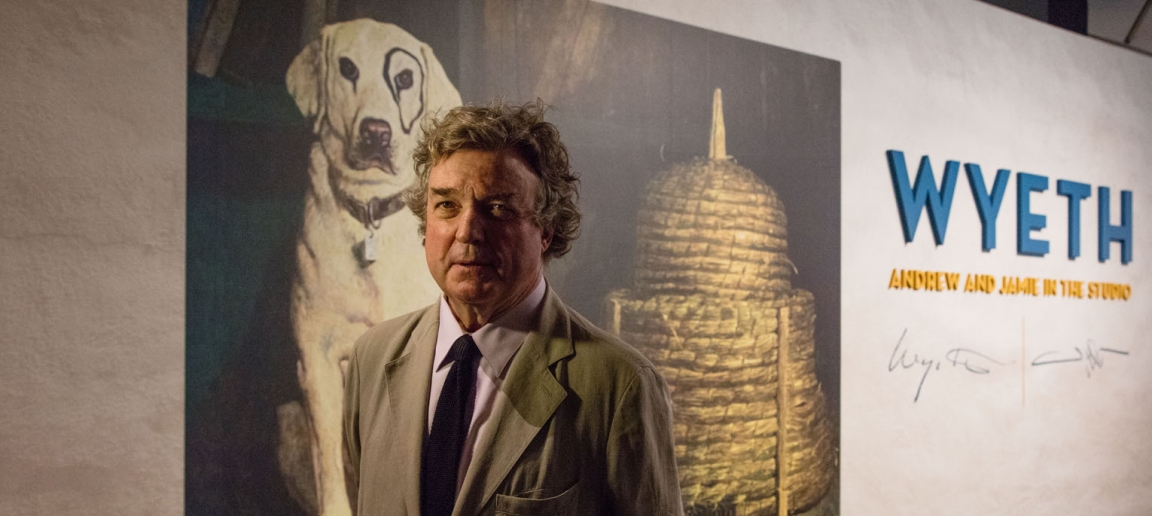 Jamie Wyeth in front of the title wall for the exhibition