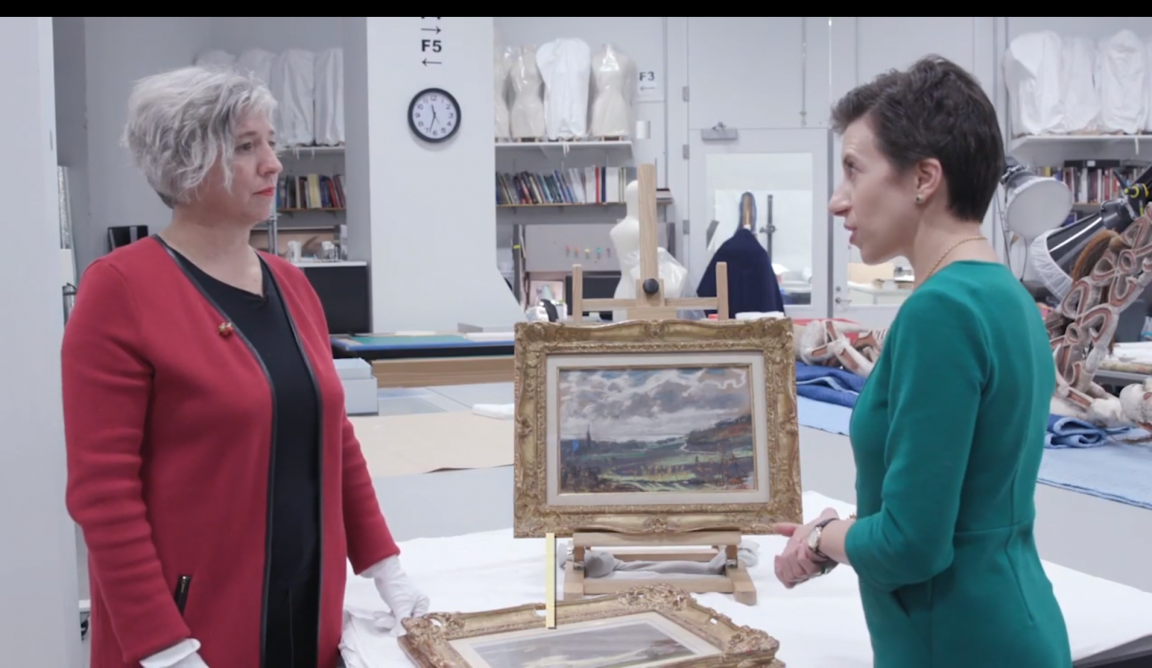 photo from video with Sarah Melching and Angelica Daneo in front of 2 framed Monet pastel artworks on a table in the conservation lab