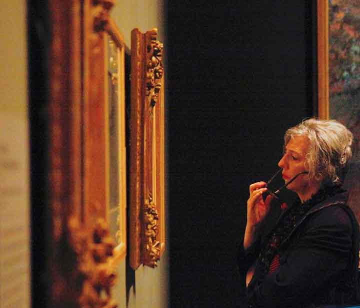 A woman looking closely at a painting