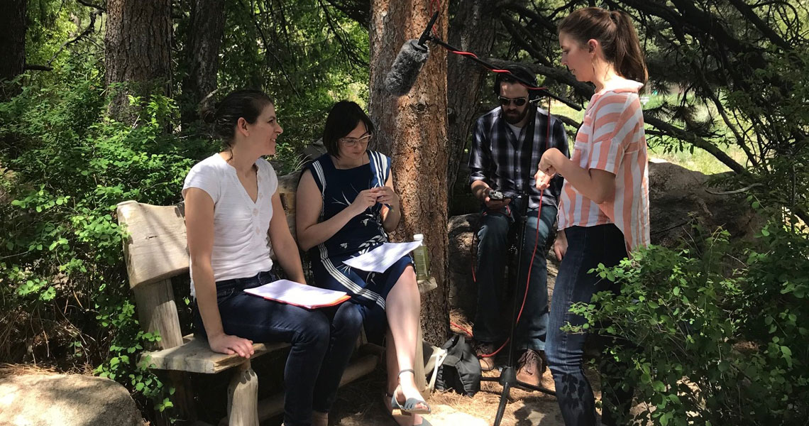 Stefania Van Dyke with Catharine McCord and 2 audio people on a bench at the Denver Botanic Gardens