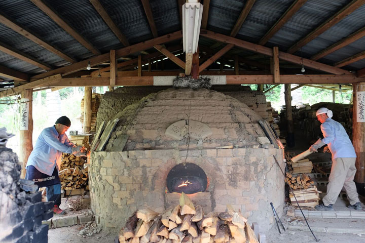 two men firing kiln