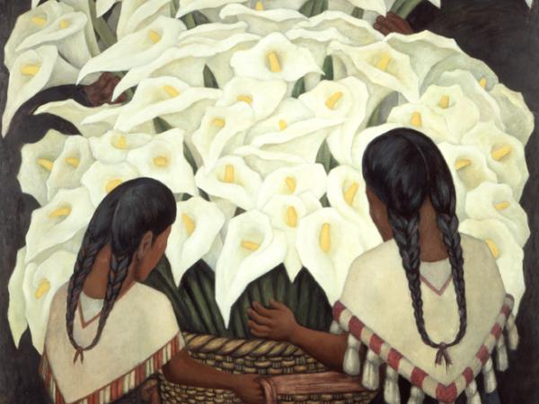Two women kneeling before a large basket of overflowing lillies