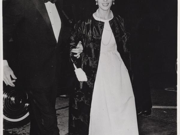 Veronique in a white dress and Gregory in a tuxedo arriving at a film premiere