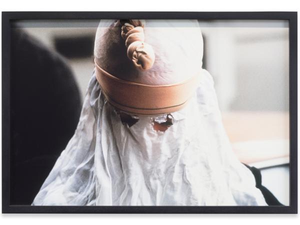 A woman hidden behind a white cloth sheet