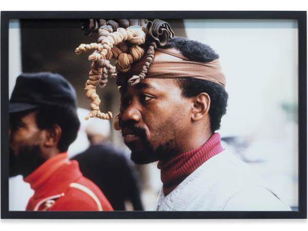 A Black man wearing an elaborate head piece.