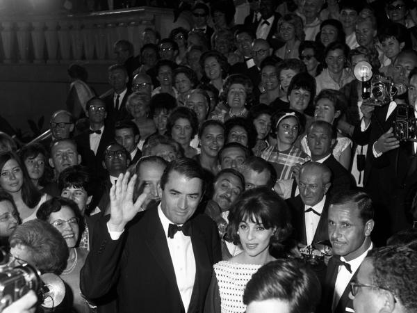 Gregory and Véronique in a large crowd of a movie premiere