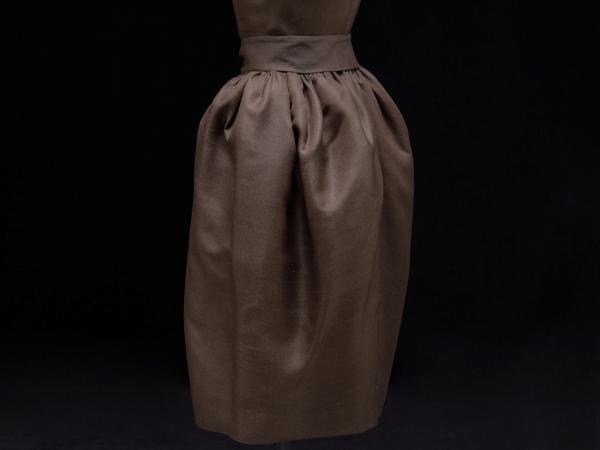 Side view of a brown couture dress with a belt