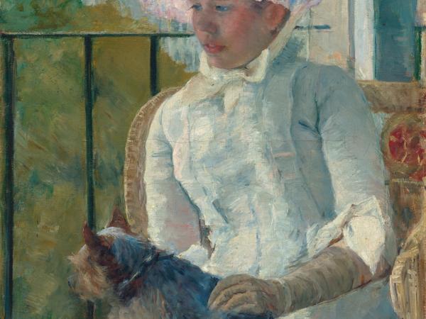 Young girl sitting at a window with her dog in her lap.