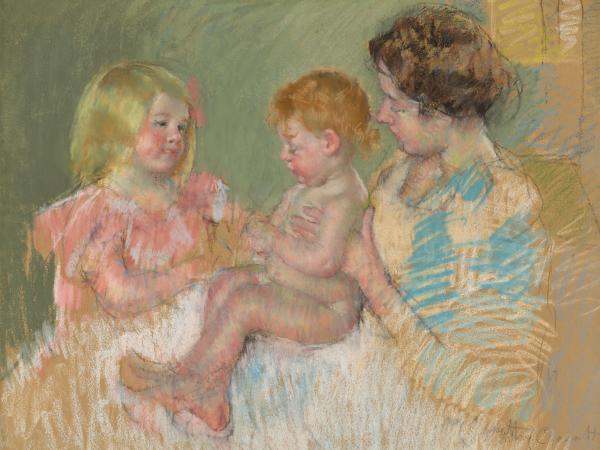 A mother with her young daughter and infant on her lap.