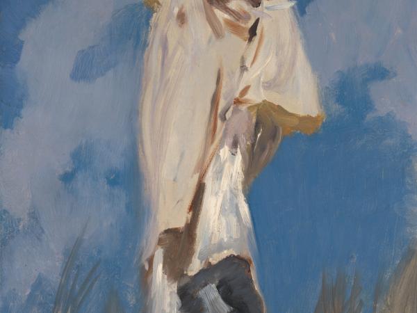 A woman holding on to her hat during a windy day.