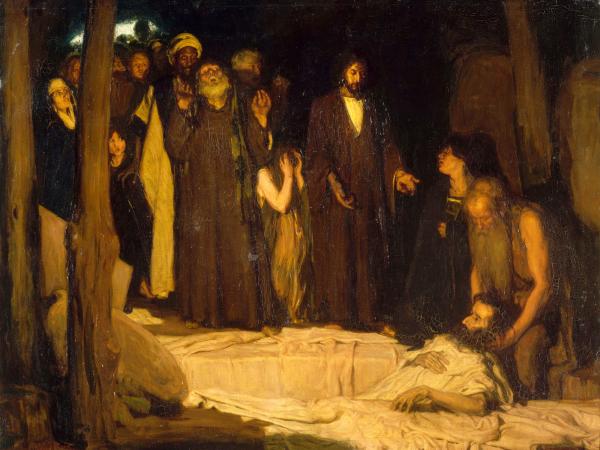 View of a group of men crowded around a man in repose.