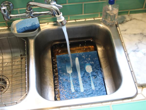 Overhead view of the print being rinsed with water in the sink
