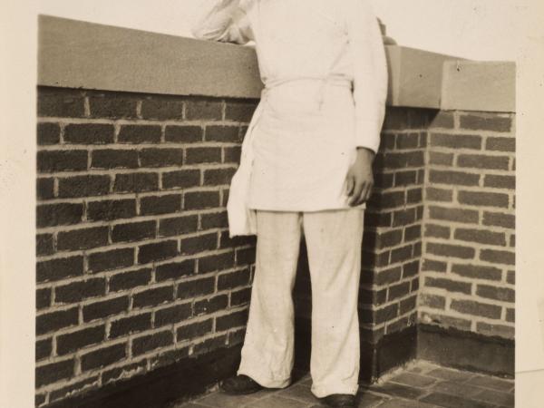 a man in kitchen uniform and apron on top of the roof