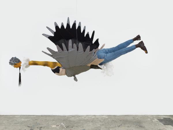 Three dimensional installation of a figure with the head and wings of a bird with the legs and feet of a human