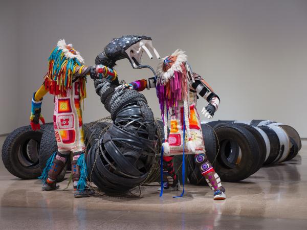 Sculpture of a black snake battling two figures