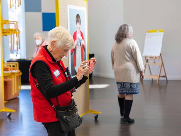 An older woman taking photos inside the exhibition