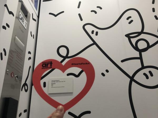 Hand holding a paper heart inside Shantell Martin's "Elevator" at the Denver Art Museum.