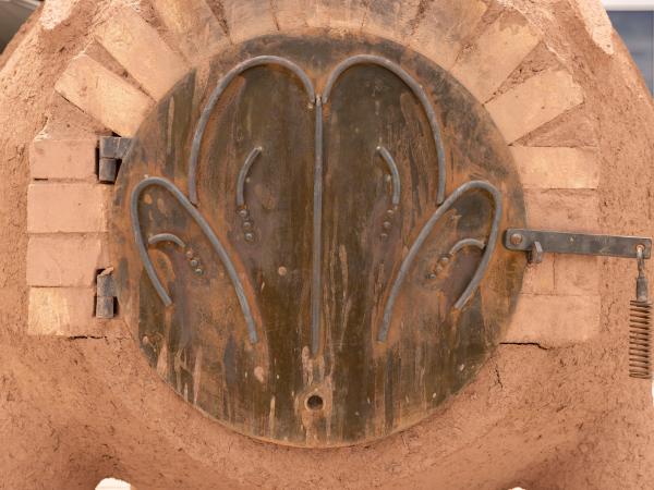 Clay structure with a metal door and handle at the center