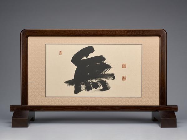 Ink on paper calligraphy encased in a table screen with a wooden frame