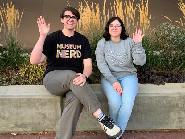 2 Shop employees wearing shirts that say Museum Nerd