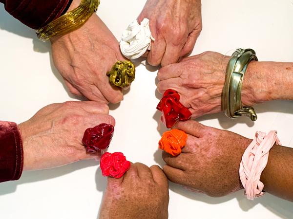 6 hands in a circle showing bracelets and rings designed by Gaetano Pesce