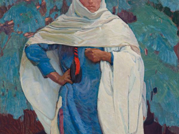 Woman dressed in blue draped in a white head and shoulder covering