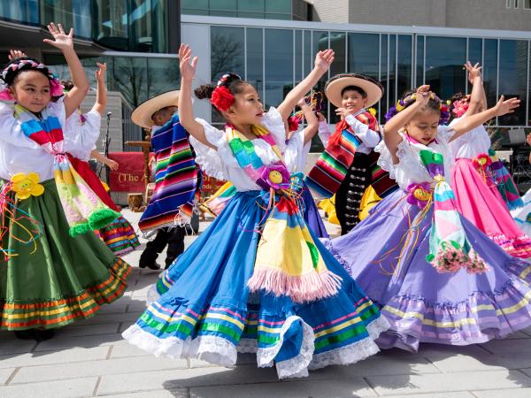 Group of children performing while dressed in traditional clothing
