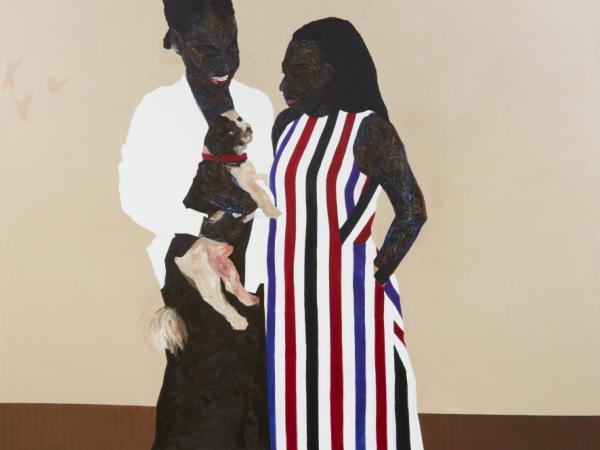 Two Black woman looking at a brown dog one of them is holding