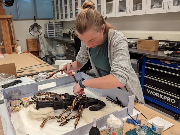 woman working on Esu in conservation lab
