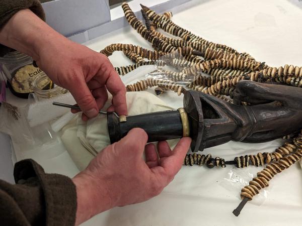 close up of hands holding mount next to Esu figure