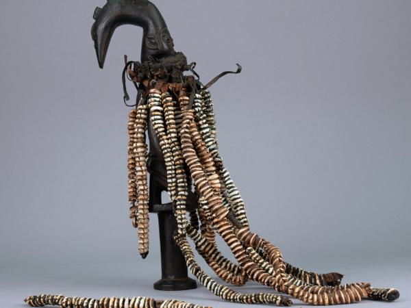 Esu figure with long necklaces of cowrie shells with one strand detached