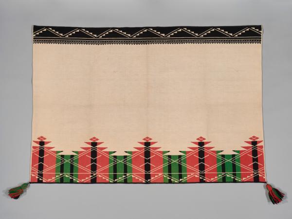 An Acoma Pueblo textile with graphic designs embroidered on the top and bottom