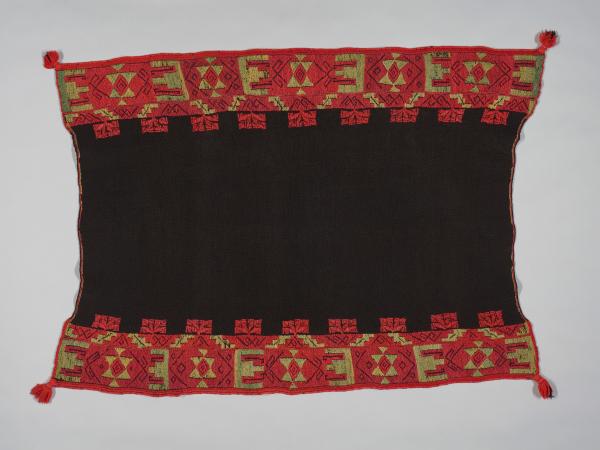 A black textile with red and gold graphic designs on the top and bottom