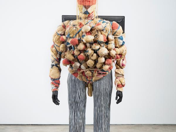 Large human-like sculpture of a man made out of TV screens