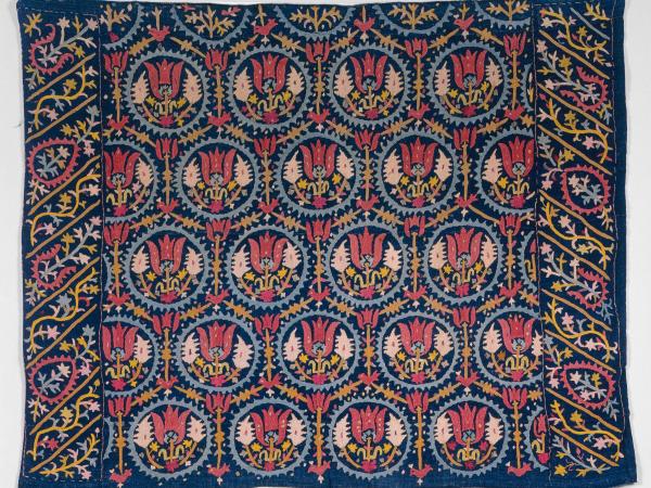 Blue cotton and wool blanket with repeating red floral patterns
