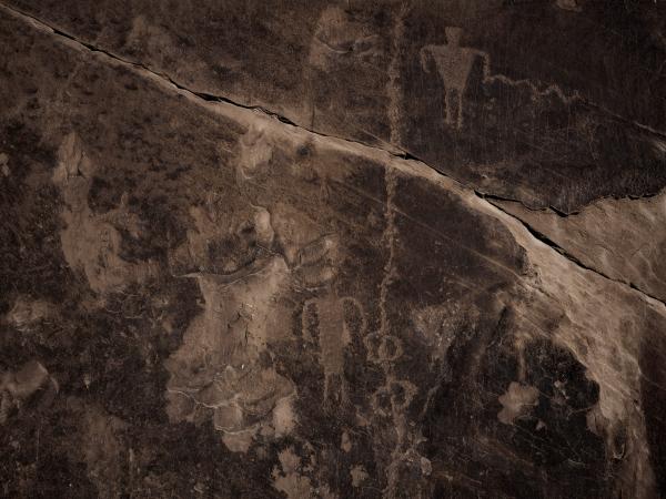 Overheard photograph of the Four Corners region depicting a dark brown ridge and flat landscape