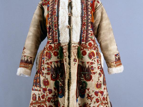 Mannequin displayng a traditional Romanian coat, embroidered with red colorful floral patterns