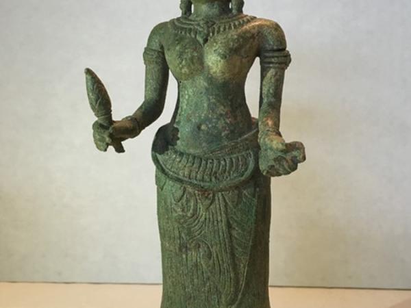 Bronze sculpture of a female figure holding a torch