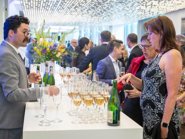 Bartender serving a woman a glass of champagne