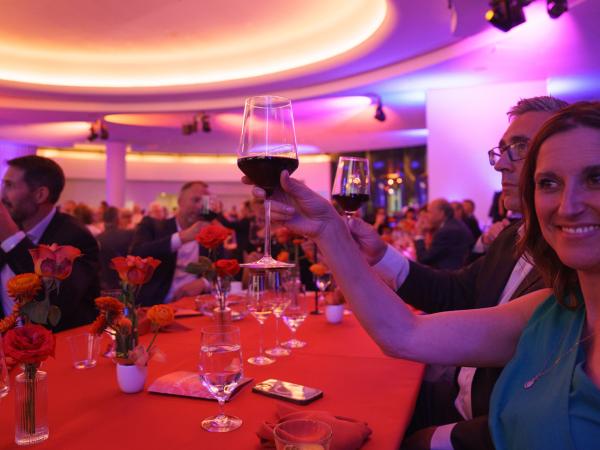 Woman raising her glass of wine to cheers the host